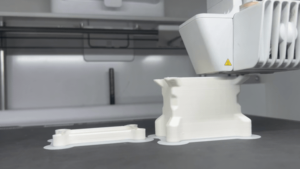 A 3D printer mid-print, extruding a white plastic enclosure part layer by layer