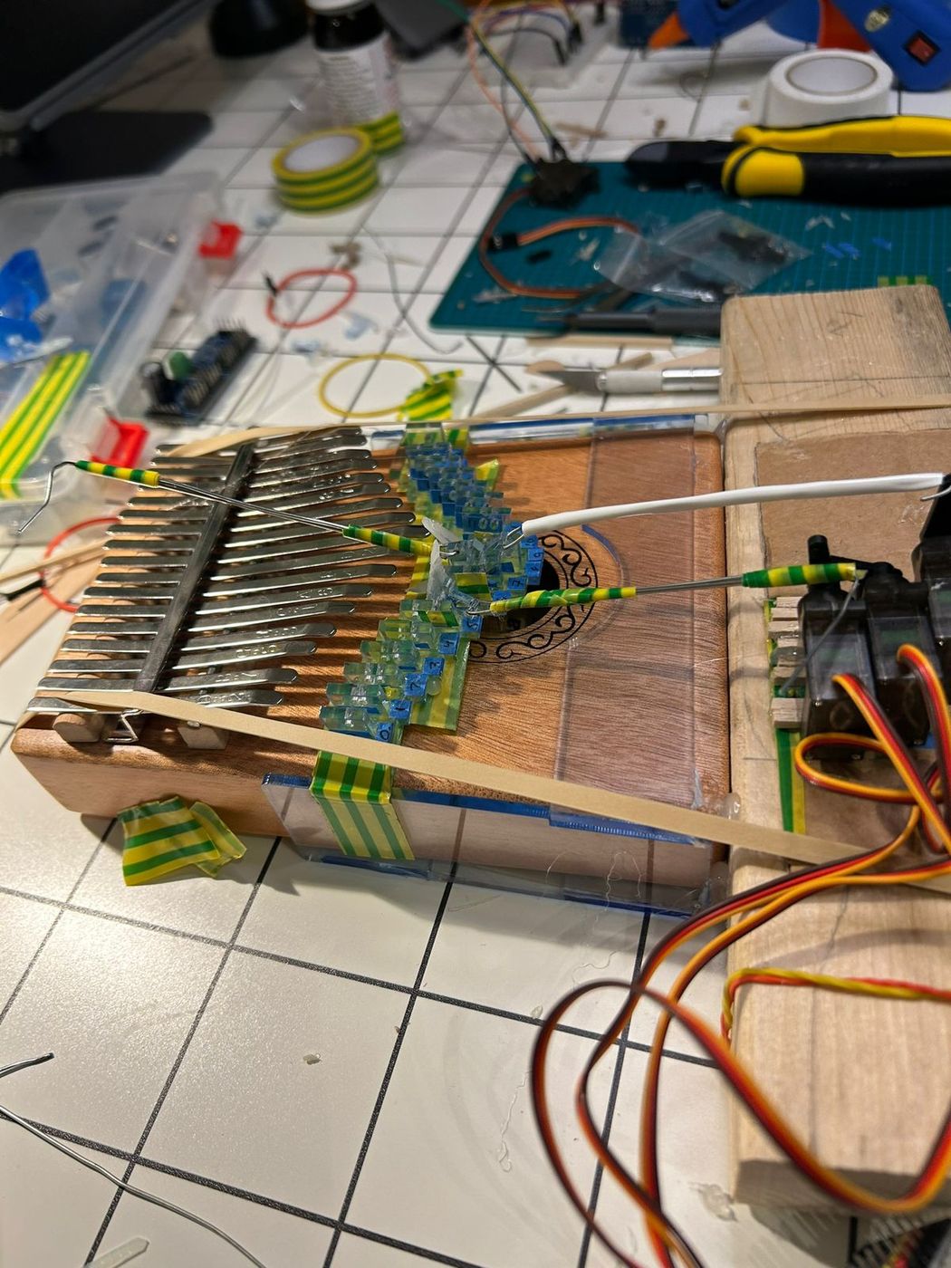 Acrylic tines fixed into a wooden base, with wiring running to the electronics