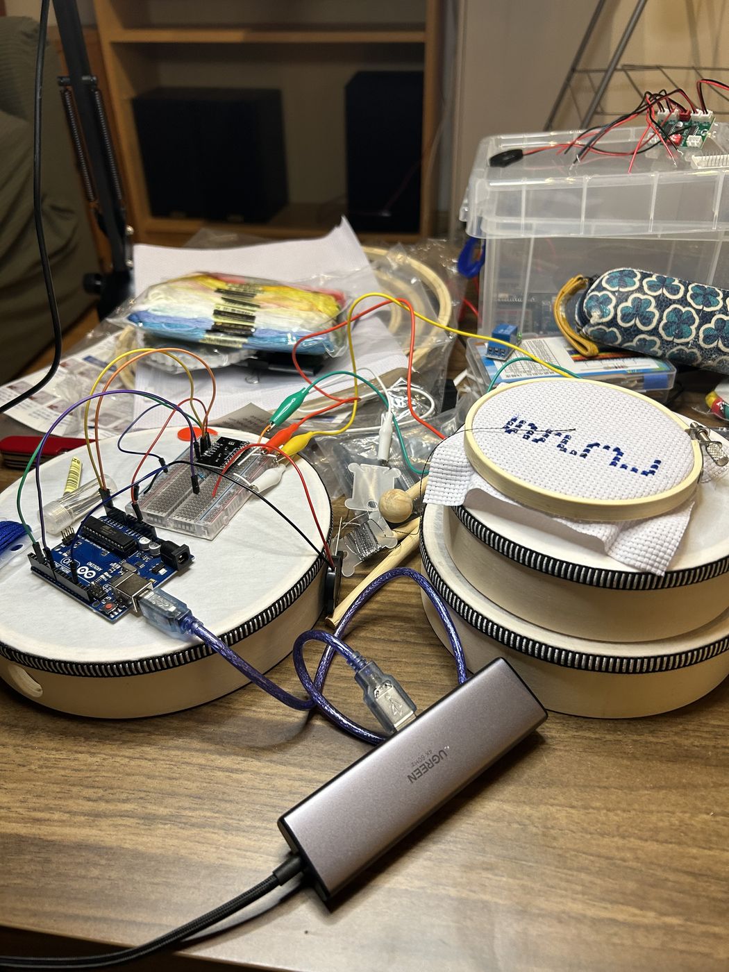 An embroidery hoop and an Arduino setup on the desk
