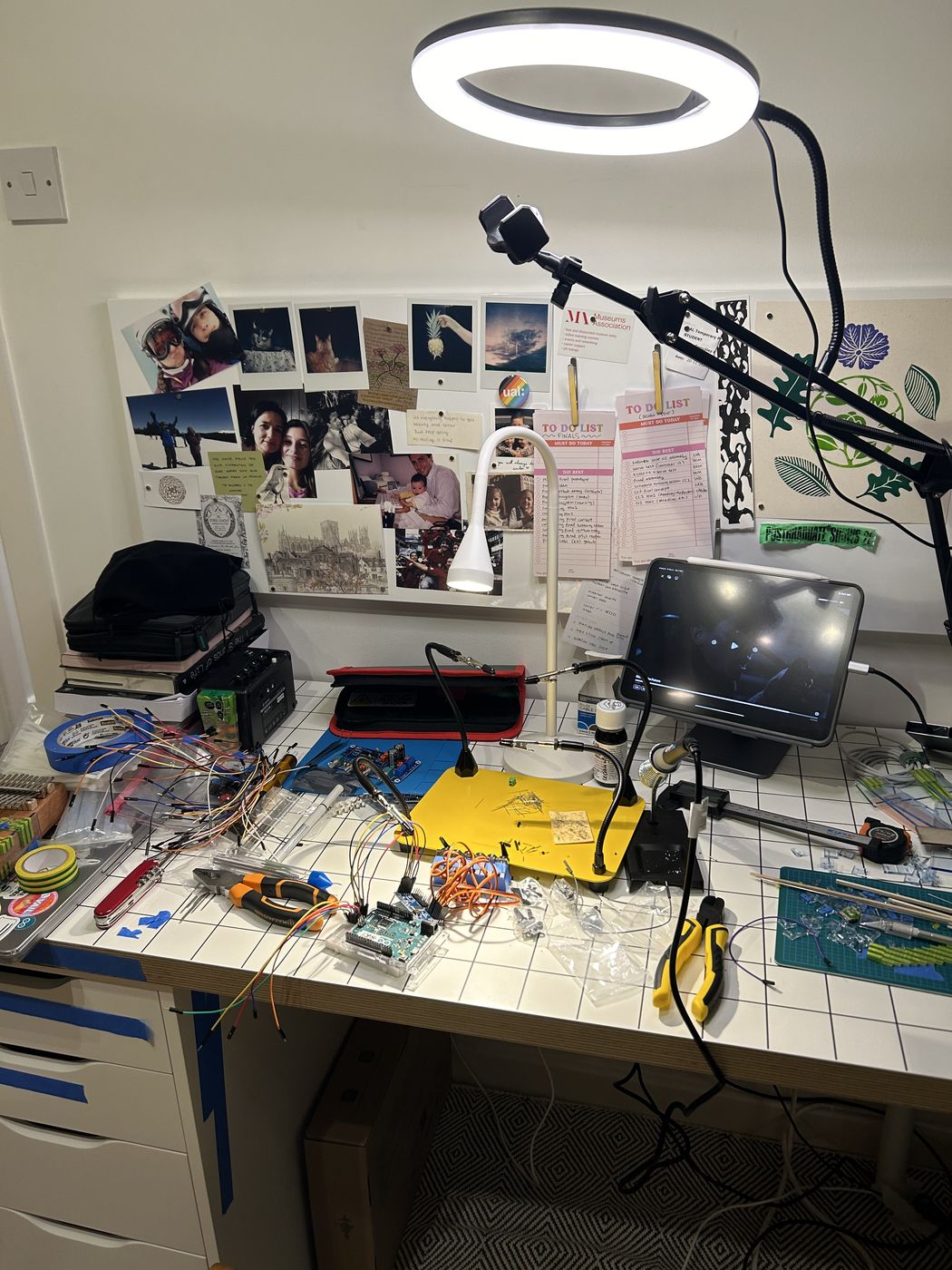 Workbench under a ring light, parts and tools spread out